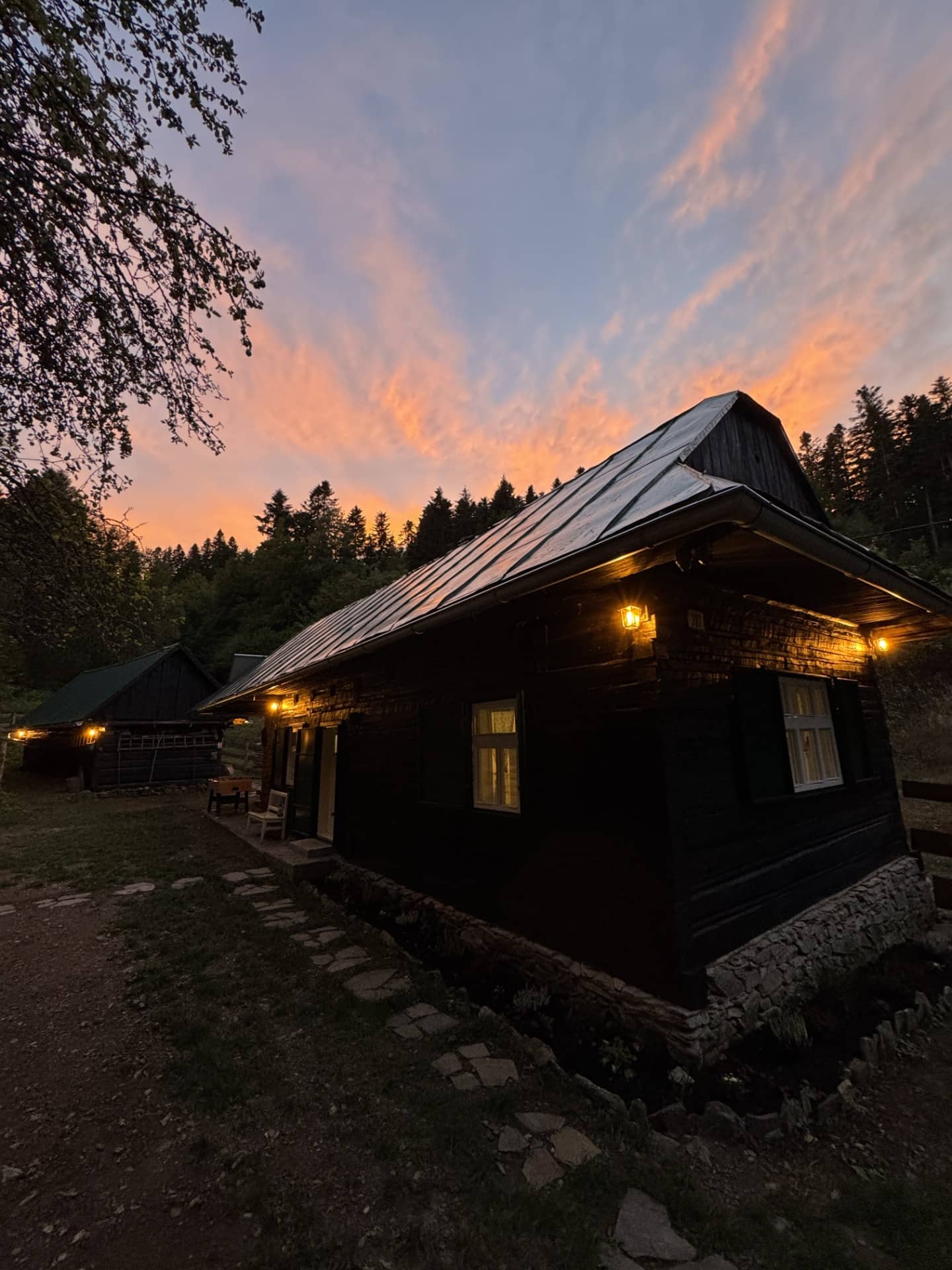 Chalupa Za Kútom za súmraku, okná svietia teplým svetlom